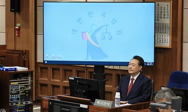 윤석열 전 대통령이 21일 오전 서울 서초동 서울중앙지법에서 열린 내란 우두머리 혐의 형사 재판 2차 공판에 출석해 피고인석에 앉아 있다. 사진공동취재단