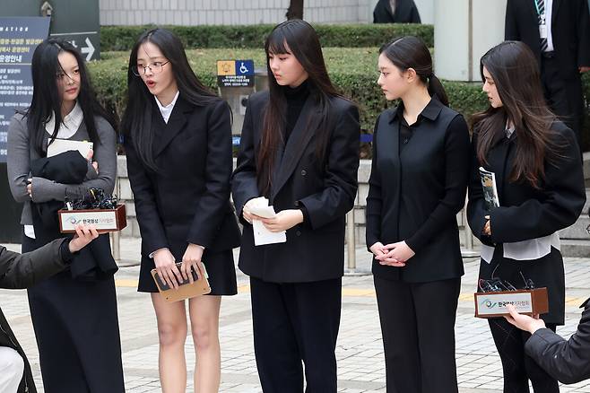 뉴진스 멤버들이 지난 3월7일 서울 서초구 서울중앙지법에서 열린 어도어의 광고계약 체결금지 및 기획사 지위보전 가처분 사건 첫 심문기일에 참석한 뒤 법원을 나서며 취재진의 질문에 답하고 있다. 왼쪽부터 하니, 민지, 혜인, 해린, 다니엘. 김영원 기자 forever@hani.co.kr