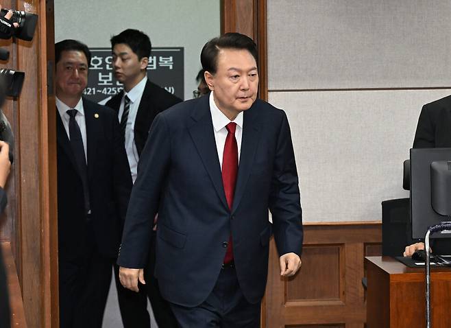 윤석열 전 대통령이 21일 서울중앙지법 417호 대법정에서 열린 내란 우두머리 혐의 형사재판 2차 공판에 출석하고 있다. 사진공동취재단