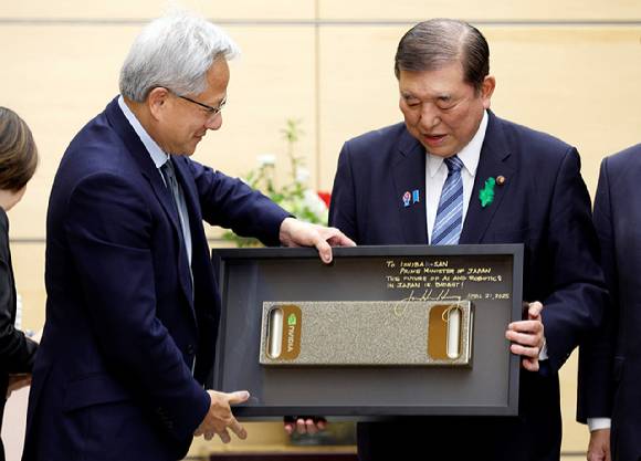 이시바 시게루 일본 총리가 21일 일본 도쿄 총리 관저에서 열린 회담 시작과 함께 엔비디아 CEO 젠슨 황으로부터 선물을 받고 있다. [사진=연합뉴스]