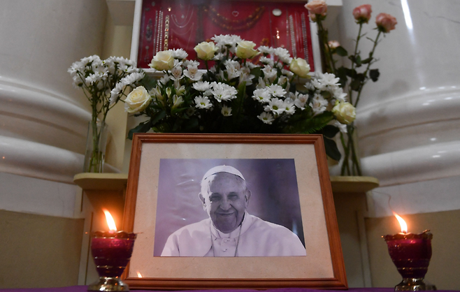 Candles burn in front of a portrait of Pope Francis at the Catholic Church of St. Catherine in Saint Petersburg, Russia on April 21. (AFP-Yonhap)