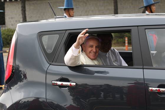 Pope Francis waves to the crowd while riding in the back seat of a Kia Soul during a visit to Korea in 2014. [JOONGANG ILBO]
