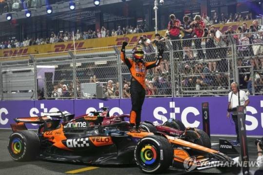 머신 위에 올라가 우승을 기뻐하는 오스카 피아스트리