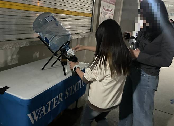 18일 오후 경기 고양시 고양종합운동장에서 열린 콜드플레이 콘서트에서 관객들이 생수통 앞에 줄을 서 물병에 물을 받고 있다. /사진= 이지현 기자.
