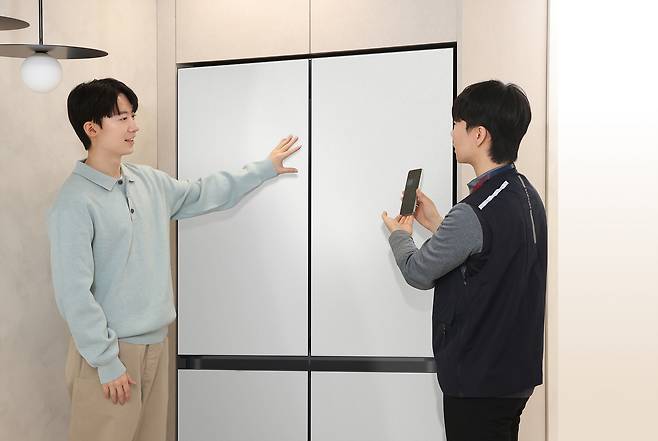 삼성전자서비스 엔지니어가 ‘AI 사전 케어 알림’ 서비스를 통해 방문 수리 서비스를 예약한 ‘AI 구독클럽’ 고객에게 상담을 제공하고 있다. [삼성전자 제공]