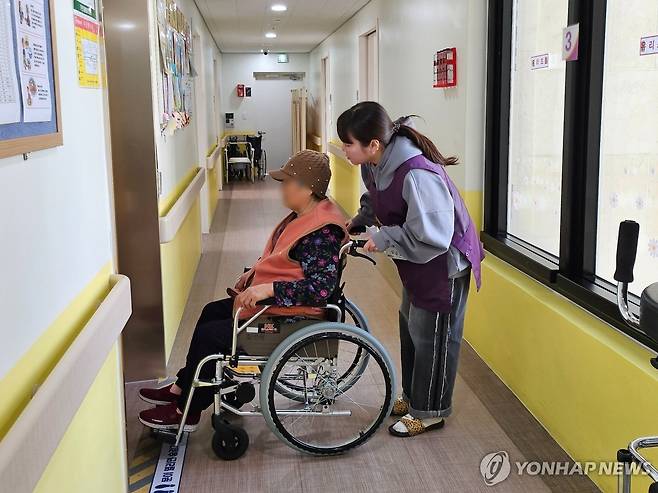 어르신 불편한 데 있으시면 말씀하세요 (서울=연합뉴스) 김유진 인턴기자 = 지난 3일 오후 경기 양주시의 가연재활요양원에서 인턴기자가 어르신의 휠체어를 끌어드리며 이야기를 나누고 있다. 2025.4.21