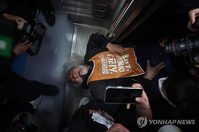 '전장연 탑승 시위'에 4호선 혜화역 하행선 무정차 통과 (서울=연합뉴스) 서대연 기자 = 박경석 전국장애인차별철폐연대(전장연) 대표가 21일 서울 지하철 4호선 혜화역에서 제62차 '출근길 지하철 탑니다' 시위를 벌이던 중 이를 저지하던 서울교통공사 관계자와 충돌하며 넘어져 있다. 
    이날 오전 9시 30분 기준 4호선 혜화역 하행선은 이 시위로 무정차 통과중이다. 2025.4.21 dwise@yna.co.kr