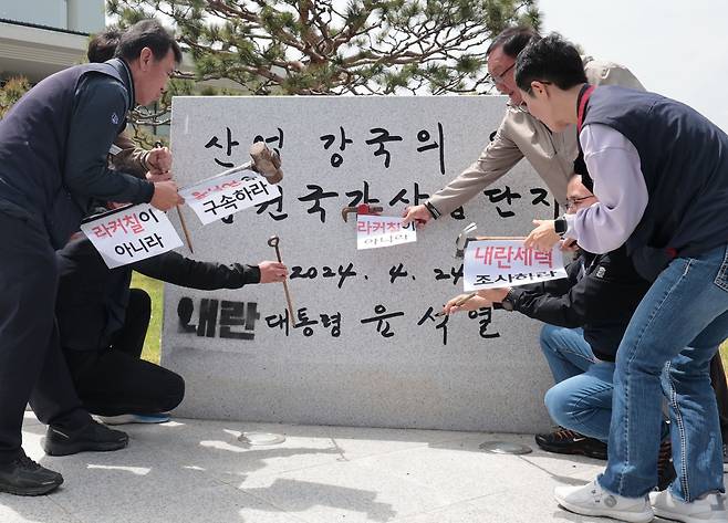 표지석 앞에서 퍼포먼스 하는 민주노총 경남본부 등 회견 참석자들 [촬영 정종호]