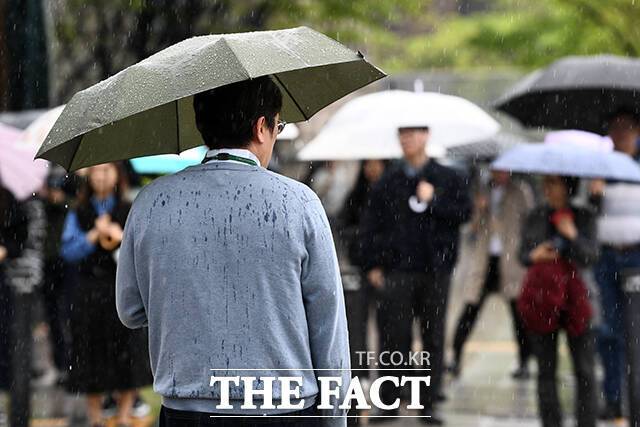 봄비가 내리는 22일 오후 서울 중구 시청역 인근에서 횡단보도 신호를 기다리는 한 시민의 등이 봄비로 젖어 있다. /서예원 기자