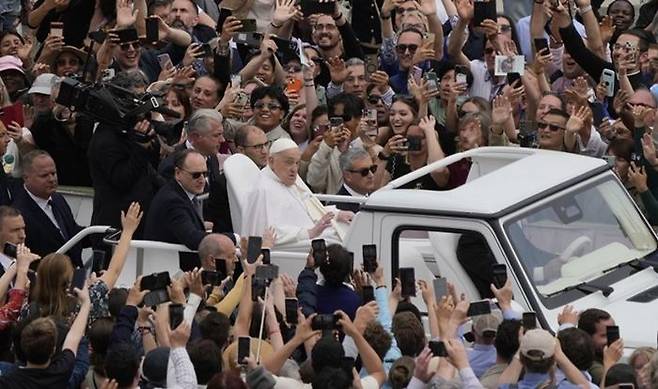 지난 20일 바티칸의 성베드로 광장에서 프란치스코 교황이 부활절 미사를 마친 뒤 대중들에 둘러싸인 채 인사를 전하고 있다. ⓒ AP/연합뉴스