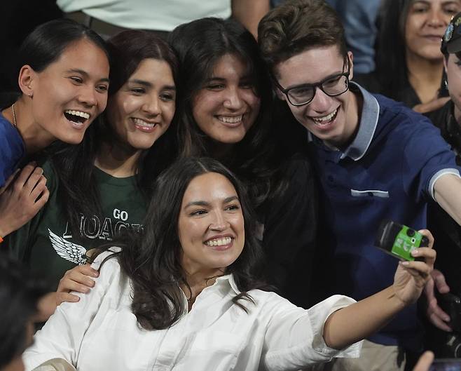 젊은층에게 인기가 많은 알렉산드리아 오카시오코르테스 미국 민주당 하원의원(아래)이 20일(현지 시간) 애리조나주 템피에서 열린 ‘과두정치 반대’ 집회에서 지지자들과 사진을 찍고 있다. 템피=AP 뉴시스