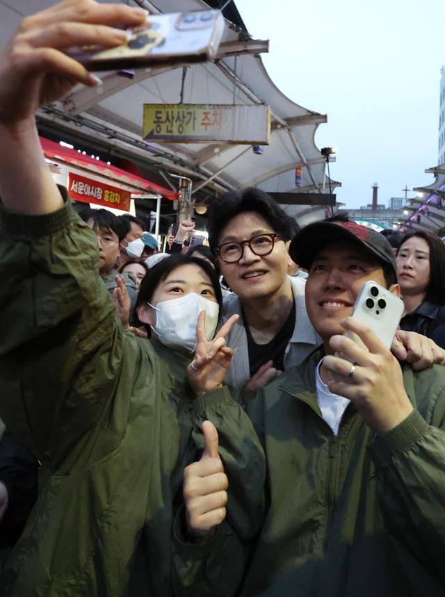 한동훈(가운데) 제21대 대통령 선거 국민의힘 경선 후보가 20일 대구 중구 서문시장 야시장을 찾아 지지자들과 기념촬영을 하고 있다. 뉴시스