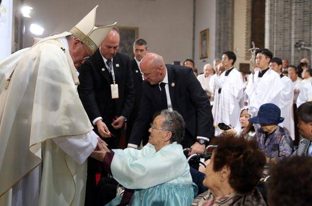 2014년 8월 18일 서울 명동성당에서 열린 '평화와 화해를 위한 미사'에서 일본군 위안부 피해자 할머니들을 위로하는 교황 모습. 연합뉴스