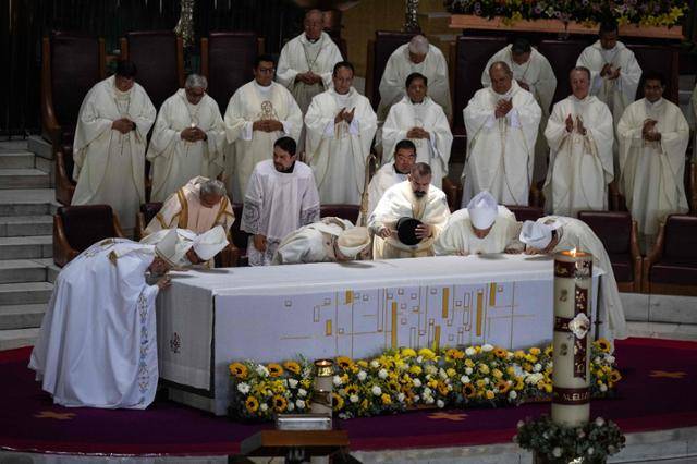 21일 프란치스코 교황이 선종하자 멕시코시티 과달루페 대성당에서 성직자들이 제단에 입을 맞추고 있다. 멕시코시티=AFP 연합뉴스