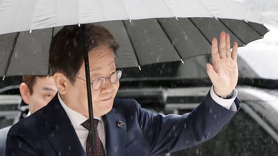 이재명 더불어민주당 전 대표가 22일 서울중앙지방법원에서 열린 '대장동 배임 및 성남FC 뇌물' 1심 속행 공판에 출석하며 지지자들에게 손인사를 하고 있다. 뉴스1