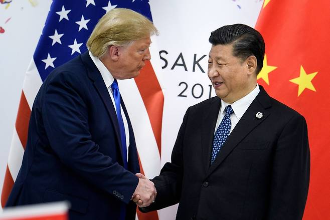 This file photo, taken on June 28, 2019, shows US President Donald Trump (left) shaking hands with China’s President Xi Jinping before a bilateral meeting on the sidelines of the G20 Summit in Osaka. (AFP-Yonhap)