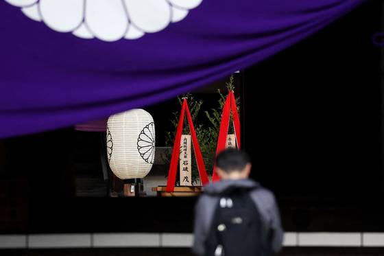 A wooden plaque showing the name of Japan's Prime Minister Shigeru Ishiba is seen with a ″masakaki″ tree that he sent as an offering to the controversial Yasukuni Shrine on the first day of the Spring Festival in Tokyo on April 21. [AFP/YONHAP]