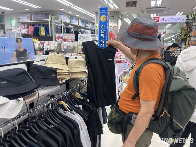 김영수(51·가명)씨가 서울의 한 다이소 매장에서 신상 스포츠 의류를 살펴보고 있다. 김씨가 들고 있는 옷의 가격은 3000원이다. 심하연 기자