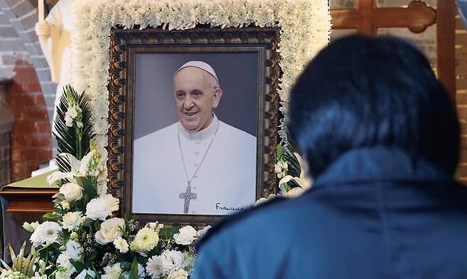 22일 서울 중구 명동대성당 지하성당을 찾은&nbsp;시민이&nbsp;전날 선종한 프란치스코 교황의 빈소 앞에서 고인을 추모하고 있다. 사진공동취재단