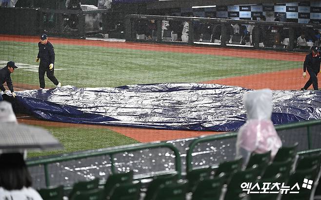 23일 오후 부산 동래구 사직야구장 열린 '2024 신한 SOL Bank KBO리그' SSG 랜더스와 롯데 자이언츠의 경기, 5회초 우천으로 인해 경기가 중단된 뒤 그라운드에 방수포가 뎦여지고 있다. 엑스포츠뉴스 DB