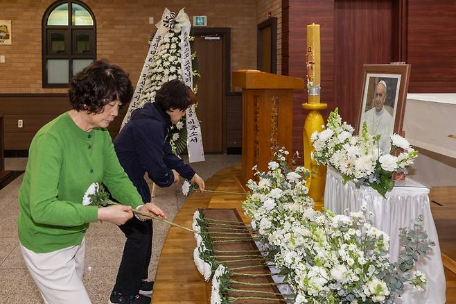 23일 울산 중구 복산성당에 마련된 프란치스코 교황 추모 분향소에서 신자들이 헌화하고 있다. 최지원 기자