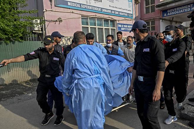 22일(현지시간) 인도 스리나가르 남쪽 아난트나그의 한 병원에서 구급대원과 경찰이 부상당한 관광객을 옮기고 있다. (사진=AFP)
