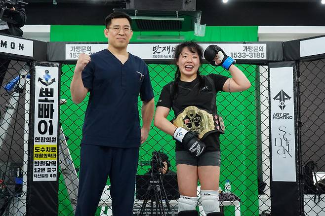 아마추어 종합격투기 대회 KMMA 여성 슈퍼스트로급 챔피언 오정은(오른쪽)이 메인스폰서인 뽀빠이연합의원 김성배 대표원장과 함께 기념촬영을 하고 있다. 사진=KMMA