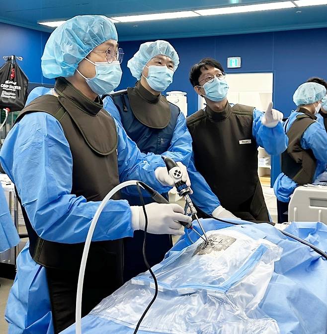 김용선 본동물의료센터 원장(왼쪽에서 세 번째)이 제1회 척추 내시경 실습 세미나에서 수의사들에게 실습을 지도하고 있다(본동물의료센터 제공). ⓒ 뉴스1