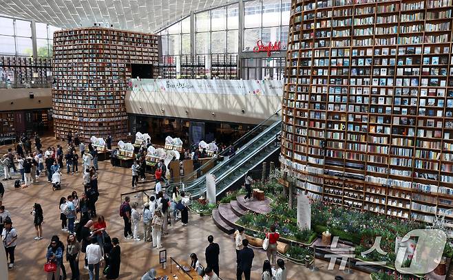 세계 책의 날인 23일 서울 강남구 코엑스 별마당 도서관에서 국내외 관람객들이 책과 함께 사진촬영 등을 하며 즐거운 추억을 만들고 있다. 이 날은 독서 출판을 장려하고 저작권 제도를 통해 지적 소유권을 보호하기 위해 1995년 유네스코 총회에서 제정됐다. 2025.4.23/뉴스1 ⓒ News1 김명섭 기자