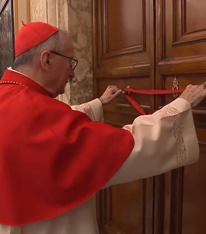 21일(현지 시간) 교황청 국무원장인 피에트로 파롤린 추기경이 프란치스코 교황이 생전 거주하던 산타 마르타의 집 문을 봉인하고 있다. 교황청 제공