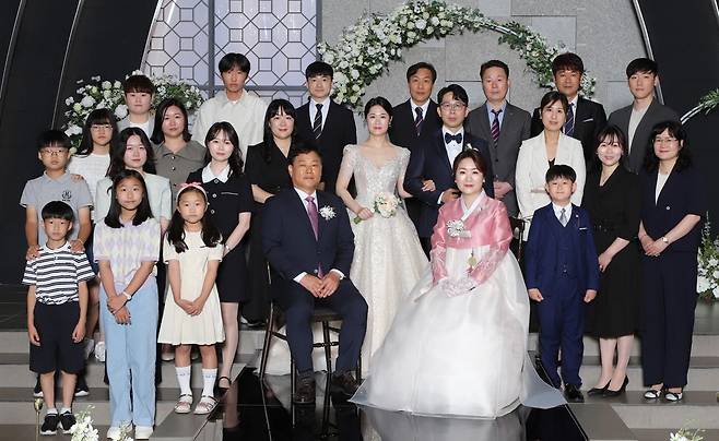 세계부부의날위원회는 ‘부부의 날’ 모범부부 대상에 박원제 우정민 씨 부부 등 20쌍을 선정하고 다음 달 21일 시상식을 개최할 예정이다. 사진은 2023년 우 씨의 막냇동생인 우정실 씨(신부) 결혼식에서 혼주석에 앉은 부부와 가족의 모습. 우정실 씨 제공