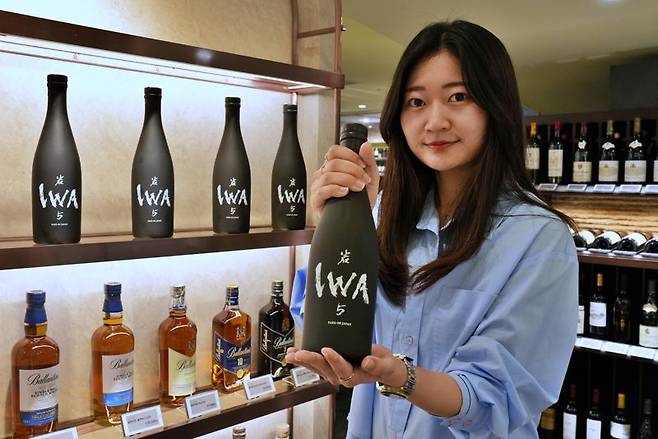 롯데백화점 본점 지하 1층 와인매장에서 직원이 '이와 5' 사케를 소개하고 있다. 롯데백화점 제공