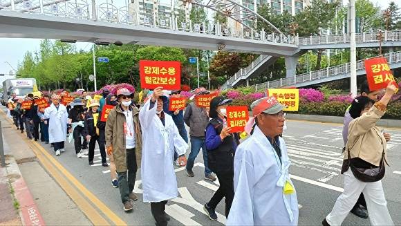 평택 지제역세권 보상대책위원회가 23일 평택시청앞에서 가두행진을 하고 있다. [사진=평택지제역세권 보상대책위원회]