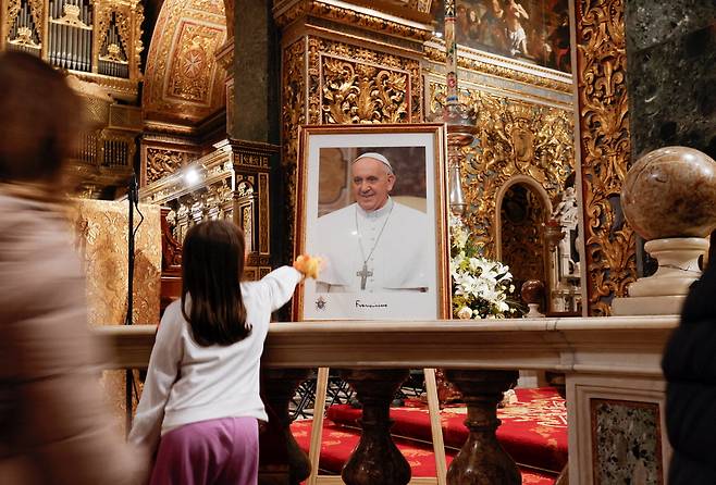 "잊지 않겠습니다"22일(현지시간) 몰타 수도 발레타의 성 요한 공동 대성당에서 프란치스코 교황을 기리는 추모미사가 진행된 후 한 어린이가 교황의 초상화를 만지고 있다.  로이터연합뉴스