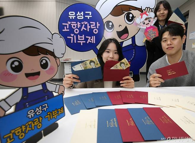 (대전=뉴스1) 김기태 기자 = 22일 대전 유성구청 직원들이 구에서 제작한 고향사랑기부제를 홍보할 수 있는 세뱃돈 봉투를 선보이고 있다.   세뱃돈 봉투는 유성구의 대표 캐릭터 '유성이'와 뱀을 활용해 디자인했으며, 다가오는 설 명절에 주민들이 사용할 수 있도록 동 행정복지센터와 커뮤니티 공간 등에 비치했다. 2025.1.22/뉴스1  Copyright (C) 뉴스1. All rights reserved. 무단 전재 및 재배포,  AI학습 이용 금지. /사진=(대전=뉴스1) 김기태 기자