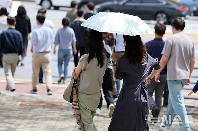 [서울=뉴시스] 이영환 기자 = 서울의 낮기온이 24도까지 오르며 초여름 날씨를 보인 23일 오후 서울 영등포구 여의도공원 앞에서 반팔을 입은 시민이 이동하고 있다. 2025.04.23. 20hwan@newsis.com