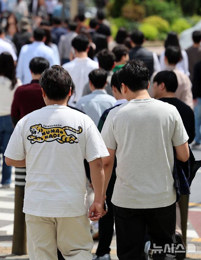 [서울=뉴시스] 이영환 기자 = 서울의 낮기온이 24도까지 오르며 초여름 날씨를 보인 23일 오후 서울 영등포구 여의도공원 앞에서 반팔을 입은 시민이 이동하고 있다. 2025.04.23. 20hwan@newsis.com