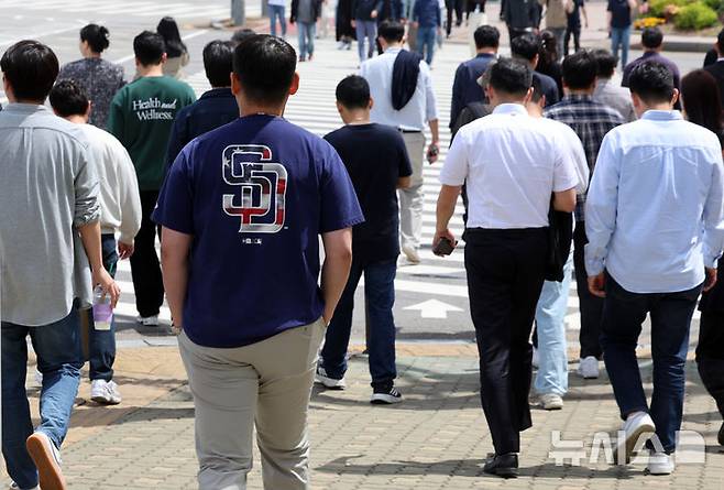 [서울=뉴시스] 이영환 기자 = 서울의 낮기온이 24도까지 오르며 초여름 날씨를 보인 23일 오후 서울 영등포구 여의도공원 앞에서 반팔을 입은 시민이 이동하고 있다. 2025.04.23. 20hwan@newsis.com