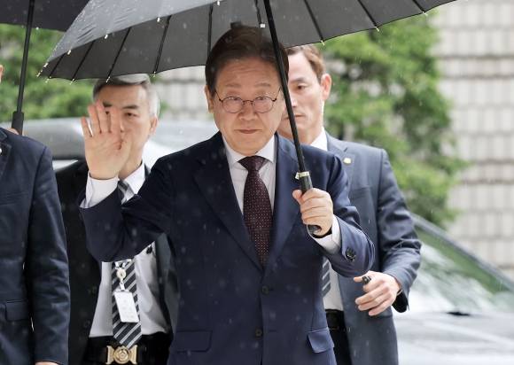 이재명 더불어민주당 대선 경선 후보가 22일 서울 서초구 서울중앙지법에서 열린 ‘대장동 배임 및 성남FC 뇌물 의혹 사건 1심 공판’에 출석하면서 지지자들을 향해 손 인사를 하고 있다. 뉴스1