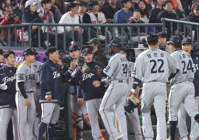 한화 선수들이 23일 부산 사직구장에서 열린 롯데와 원정 경기에서 이닝을 마친 뒤 더그아웃에서 하이파이브하고 있다. 연합뉴스