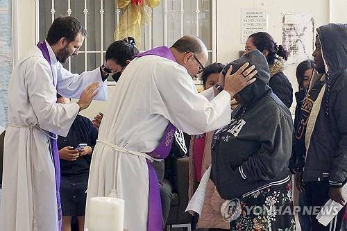 이주민을 축복하고 있는 예수회 신부들  [AP=연합뉴스 자료사진. 재판매 및 DB금지]