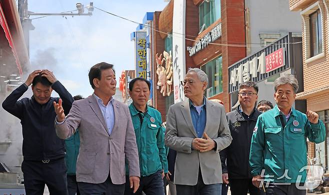 유인촌 문화체육관광부 장관이 23일 산불 피해 지역인 경북 영덕을 찾아 대표 관광지인 대게거리에서 관계자와 상점을 살펴보고 있다.(문화체육관광부 제공)