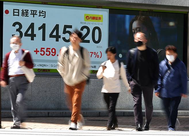 지난 14일 일본 도쿄의 한 증권사 밖에서 보행자들이 닛케이 주가 평균을 보여주는 주식 시세 게시판을 지나가고 있습니다. /로이터 연합뉴스