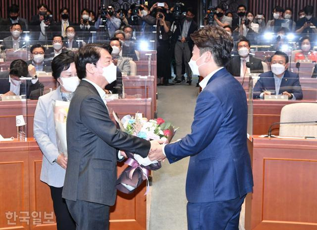 2022년 6월 14일 이준석(앞줄 오른쪽) 당시 국민의힘 대표가 국회의사당에서 열린 의원총회에 참석해 성남 분당갑 6·1 보궐선거 승리를 거둔 안철수(왼쪽) 의원에게 꽃다발을 전달하고 있다. 한국일보 자료사진