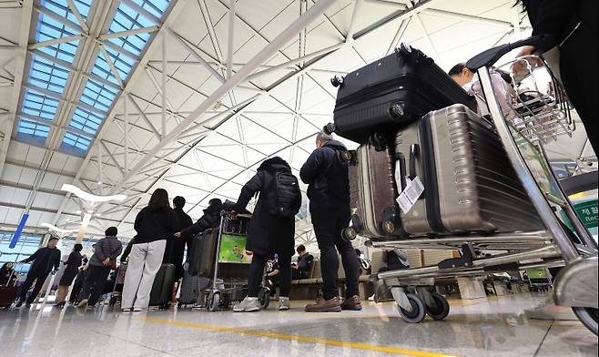 <yonhap photo-3499="">인천국제공항 제1여객터미널 출국장에서 승객들이 탑승 수속을 위해 줄을 서고 있다. 연합뉴스</yonhap>