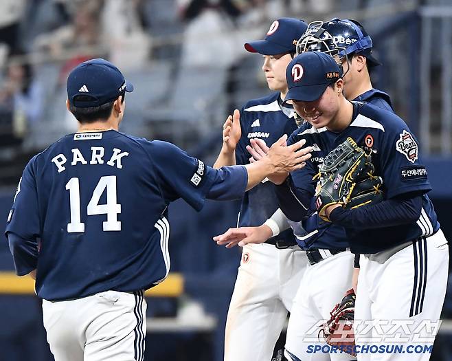 9회초 선두 타자의 평범한 땅볼 타구를 놓친 3루수 박계범이 홍민규에게 다가갔다. 미안함과 함께 축하를 전하자 홍민규도 활짝 웃었다.