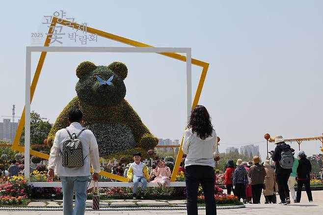 ‘2025 고양국제꽃박람회’ 개막일인 25일 경기도 고양시 일산호수공원 메인 조형물인 ‘황금빛 판다’ 앞에서 시민들이 사진을 찍고 있다. 정용일 선임기자 yongil@hani.co.kr
