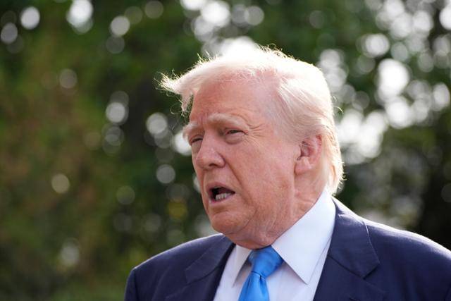 도널드 트럼프 미국 대통령이 25일 미국 수도 워싱턴 백악관에서 자신의 전용 헬기인 마린원에 탑승하기 전 기자들의 질문에 답변하고 있다. 워싱턴=AP 연합뉴스