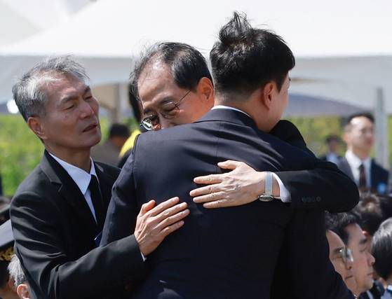 한덕수 대통령 권한대행 국무총리가 25일 국립대전현충원에서 열린 '2회 순직의무군경의 날 기념식'에서 편지 낭독을 마친 고(故) 이충주 육군 일병의 유족 이화주 씨를 위로하며 안아주고 있다. 연합뉴스