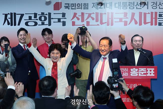 홍준표 국민의힘 대선 경선 후보가 지난 14일 서울 여의도 대하빌딩 캠프 사무소에서 대통령 선거 출마 선언을 하며 부인 이순삼 씨와 함께 손을 들어 보이고 있다. 성동훈 기자